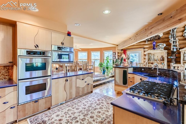 kitchen featuring tasteful backsplash, appliances with stainless steel finishes, sink, light wood-type flooring, and log walls