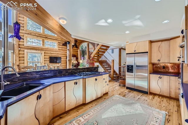 9 Arapahoe St, Woodland Park, CO 80863 - kitchen with appliances with stainless steel finishes, rustic walls, light brown cabinets, a sink, and dark countertops