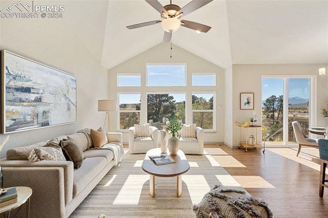 living room with light hardwood / wood-style floors, high vaulted ceiling, and ceiling fan