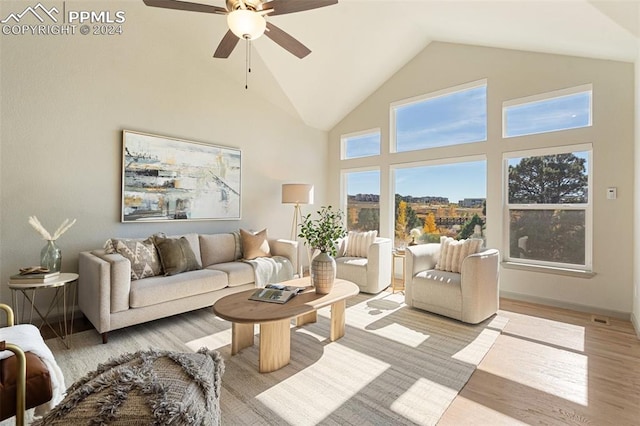 living room featuring high vaulted ceiling, light wood-type flooring, and ceiling fan