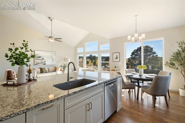 kitchen with hanging light fixtures, stainless steel dishwasher, dark hardwood / wood-style floors, ceiling fan with notable chandelier, and sink