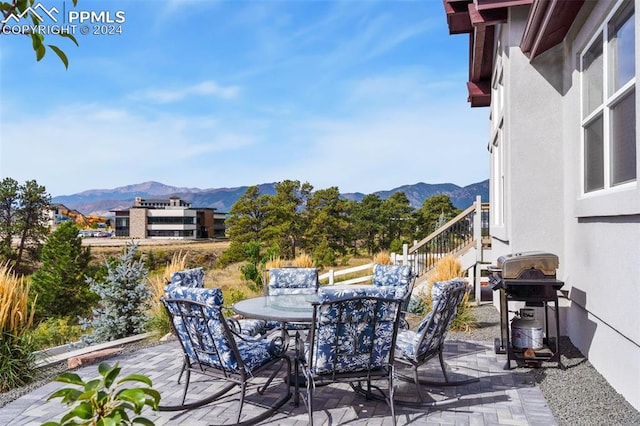 wooden terrace with area for grilling, a mountain view, and a patio