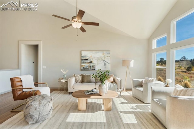 living room featuring high vaulted ceiling, light hardwood / wood-style floors, and ceiling fan