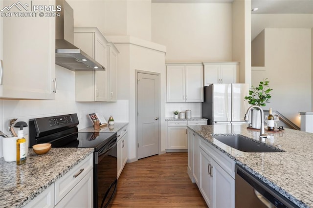 kitchen featuring white cabinets, sink, light hardwood / wood-style floors, wall chimney exhaust hood, and stainless steel appliances