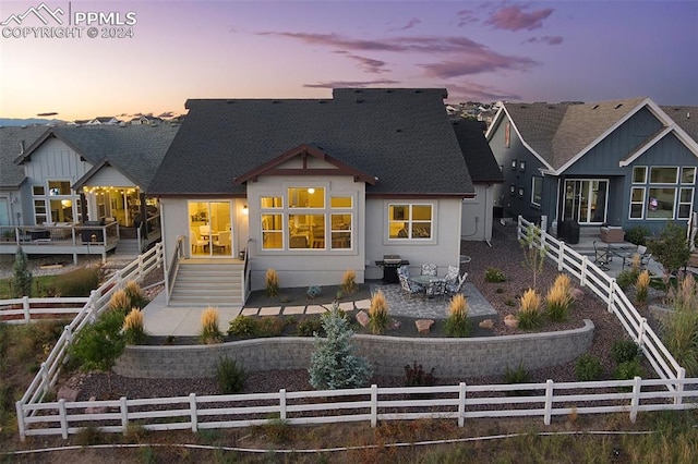 back house at dusk featuring outdoor lounge area and a patio area