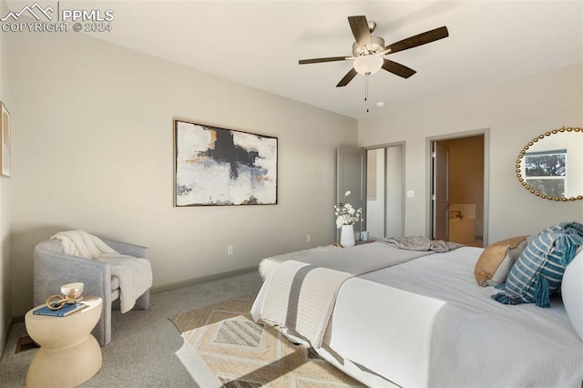 bedroom featuring ensuite bath, light carpet, and ceiling fan