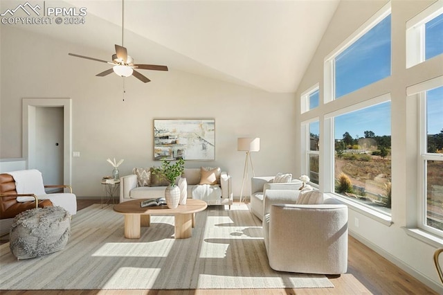 living room with light hardwood / wood-style floors, high vaulted ceiling, a healthy amount of sunlight, and ceiling fan