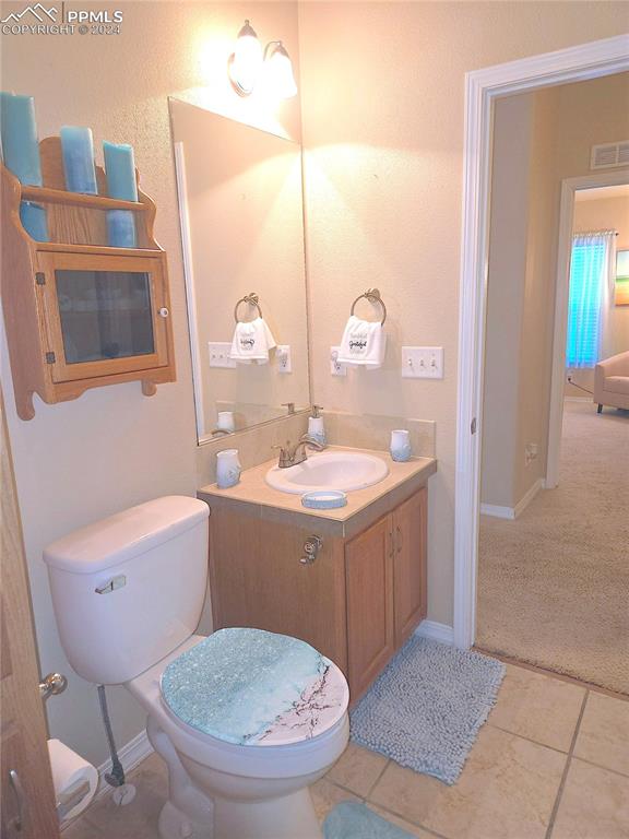 bathroom featuring tile patterned floors, vanity, and toilet