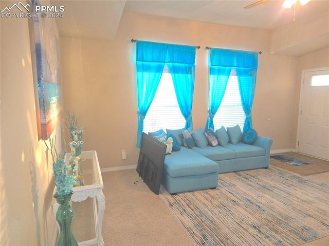 carpeted living room with ceiling fan and plenty of natural light