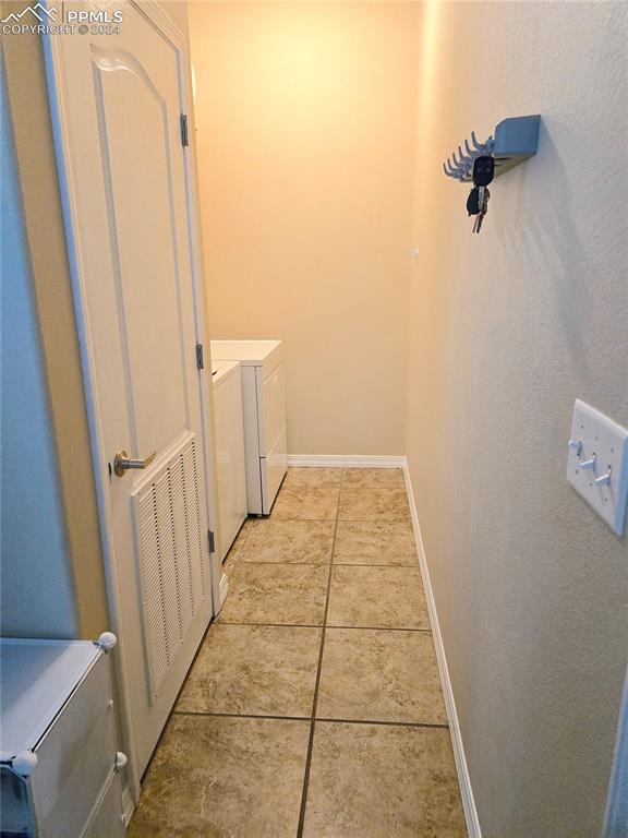 laundry room with light tile patterned flooring and washer and dryer