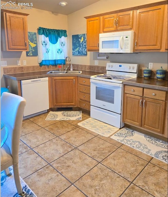 kitchen with white appliances, sink, and light tile patterned floors