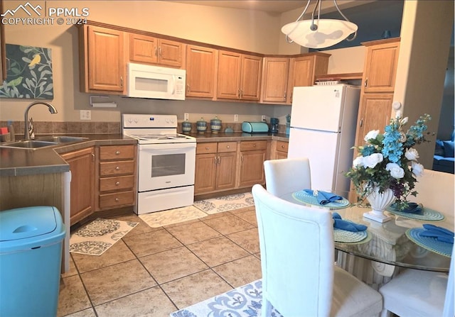 kitchen featuring lofted ceiling, white appliances, sink, light tile patterned flooring, and pendant lighting