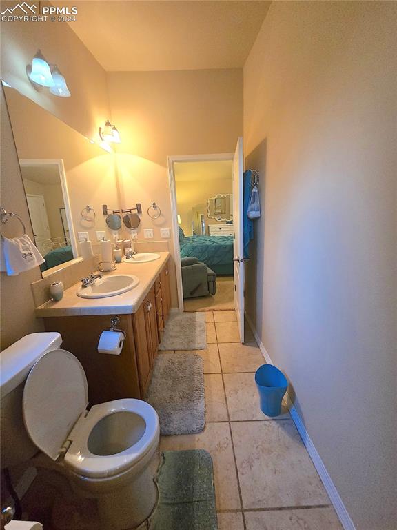 bathroom featuring vanity, tile patterned flooring, and toilet