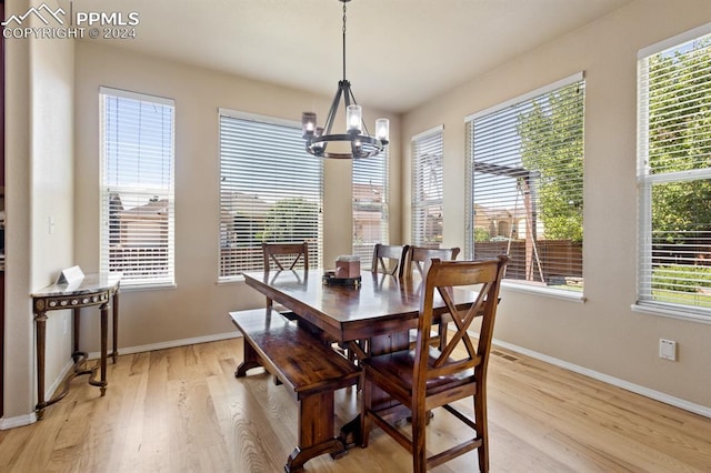 dining room featuring light wood-type flooring, a notable chandelier, and a wealth of natural light