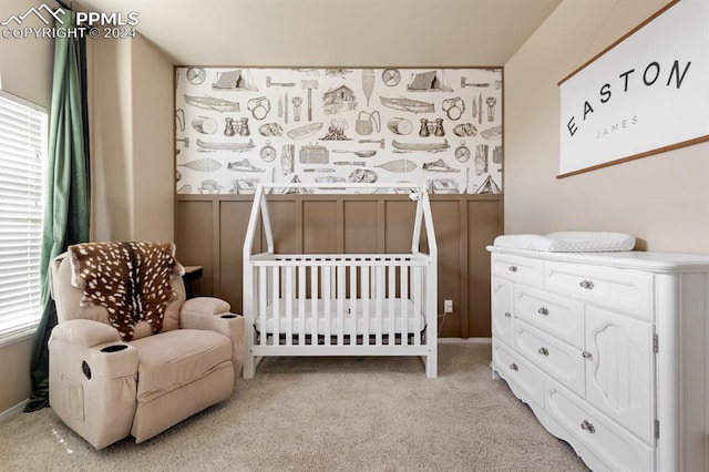 carpeted bedroom featuring a nursery area