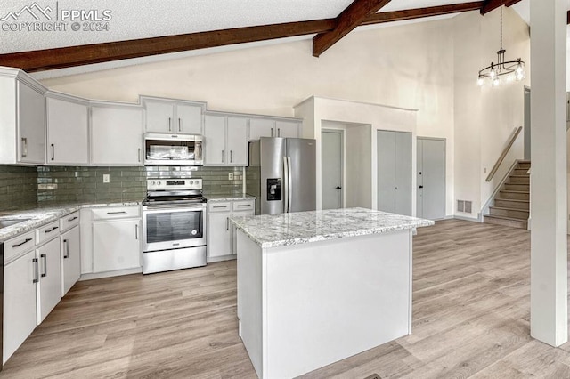 kitchen with beamed ceiling, light hardwood / wood-style flooring, hanging light fixtures, backsplash, and appliances with stainless steel finishes