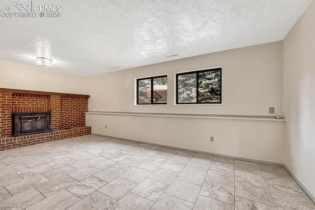 unfurnished living room with a wood stove and a textured ceiling