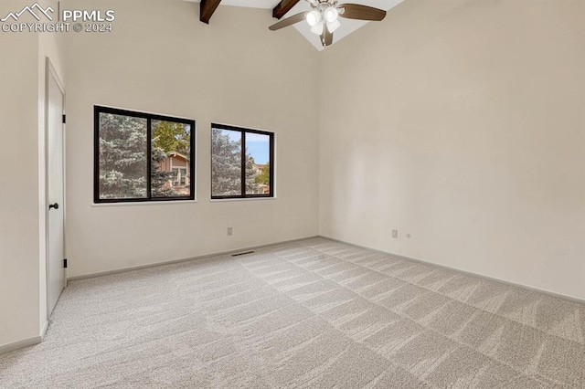 unfurnished room with ceiling fan, light colored carpet, beam ceiling, and high vaulted ceiling