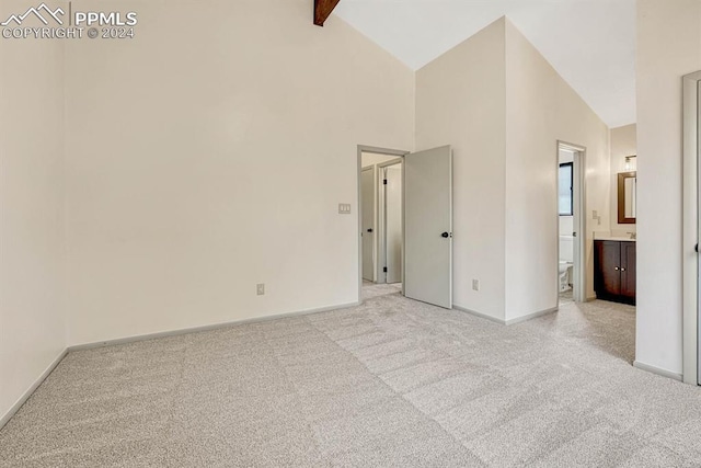 carpeted spare room with high vaulted ceiling and beamed ceiling