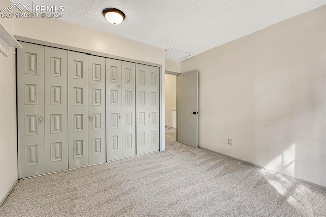 unfurnished bedroom featuring a closet, carpet, and a textured ceiling