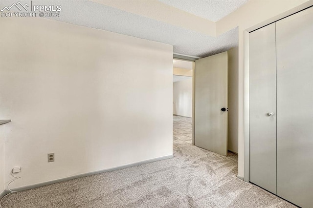 carpeted empty room featuring a textured ceiling