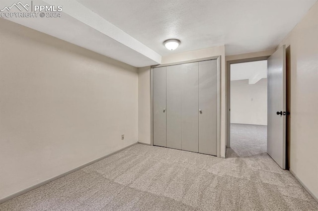 unfurnished bedroom featuring light carpet and a closet