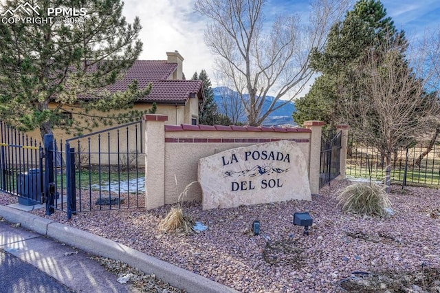 community / neighborhood sign with a mountain view