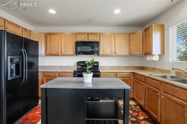 kitchen with sink, black appliances, and a center island