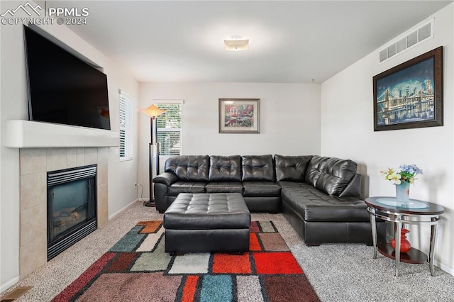 living room featuring carpet flooring and a tile fireplace