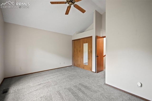 carpeted spare room with ceiling fan and high vaulted ceiling