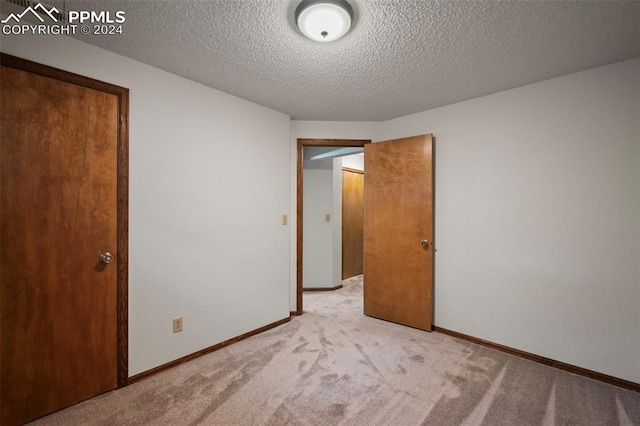 carpeted spare room with a textured ceiling