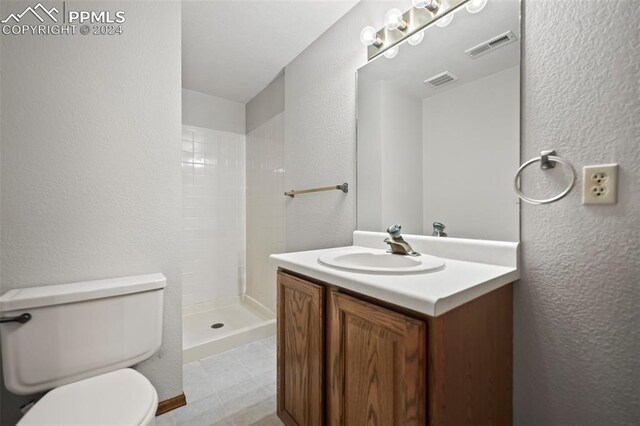 bathroom with vanity, toilet, and a shower