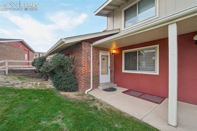 doorway to property with a yard and a patio area