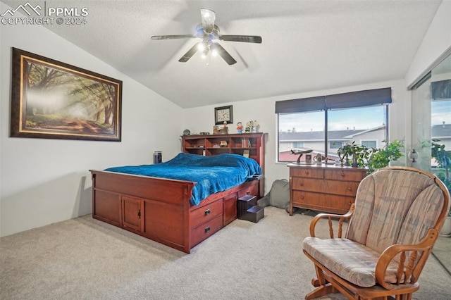 carpeted bedroom with a textured ceiling, vaulted ceiling, and ceiling fan