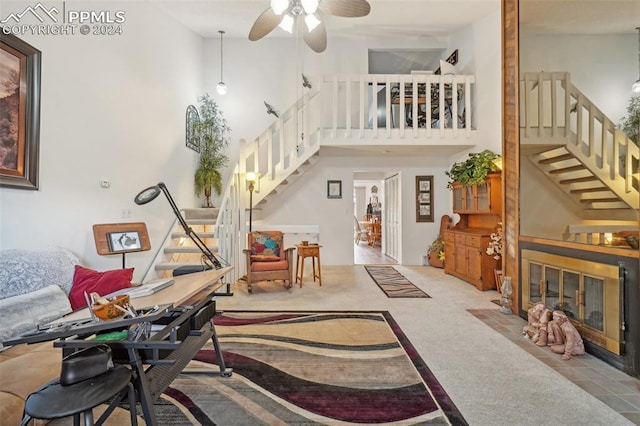 interior space with a high ceiling, light carpet, and ceiling fan