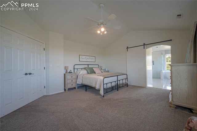 bedroom with a barn door, ceiling fan, a closet, vaulted ceiling, and dark colored carpet