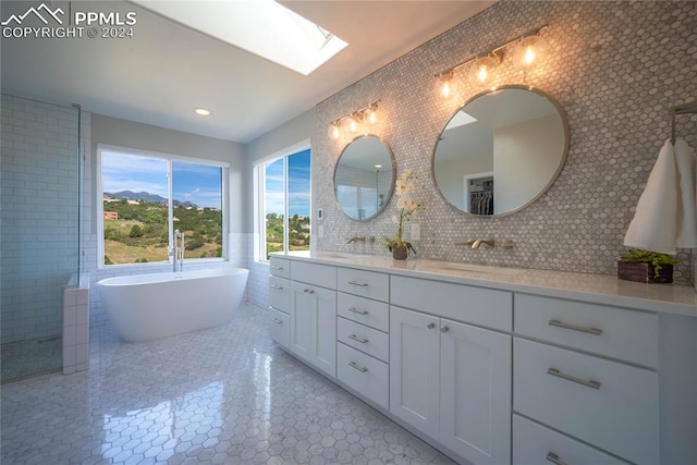 bathroom featuring a skylight, tasteful backsplash, a tub, tile walls, and vanity