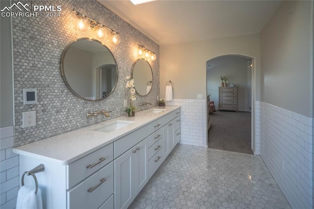 bathroom featuring vanity and tile walls