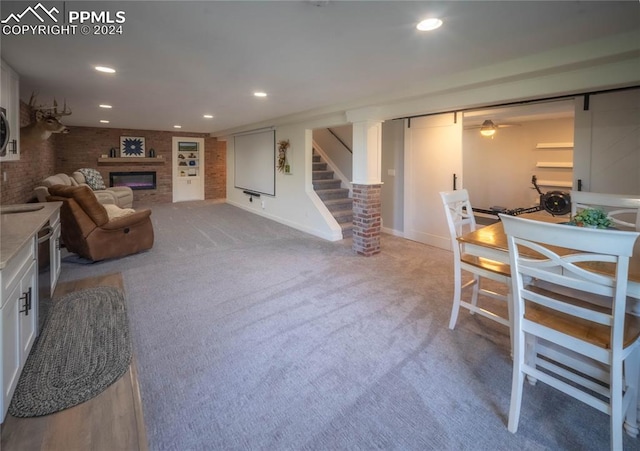 carpeted living room featuring brick wall