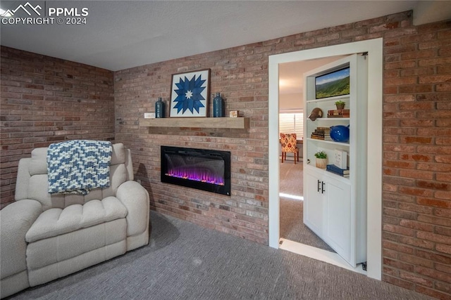 living room with brick wall, a fireplace, and carpet flooring