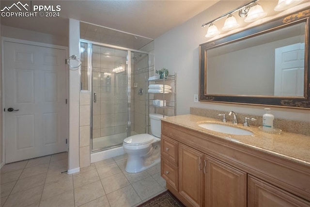 bathroom featuring tile patterned flooring, an enclosed shower, vanity, and toilet