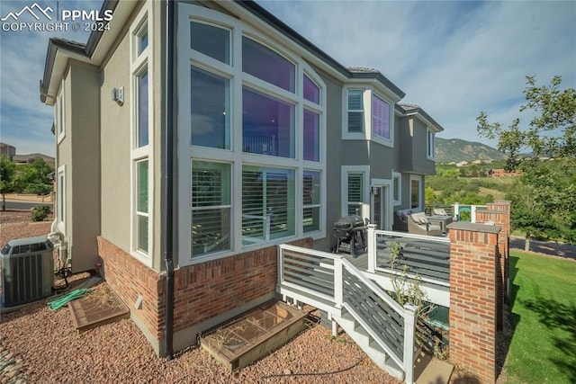 view of side of property featuring central air condition unit and a mountain view