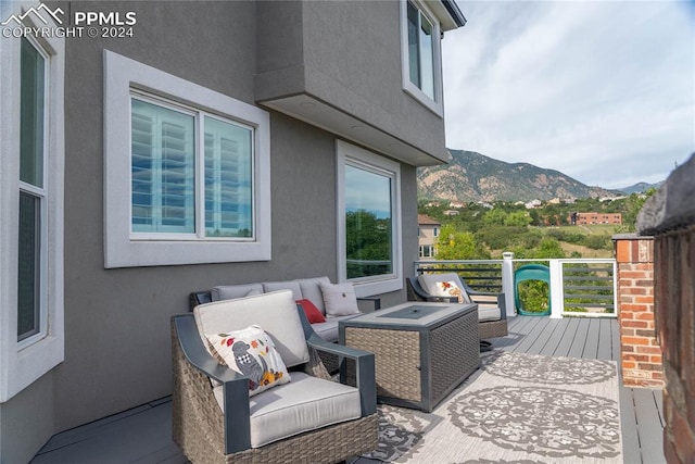 wooden deck with an outdoor hangout area and a mountain view