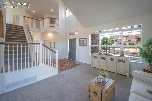 carpeted living room with high vaulted ceiling