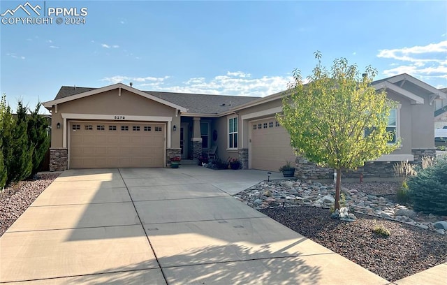 single story home with a garage, stone siding, concrete driveway, and stucco siding