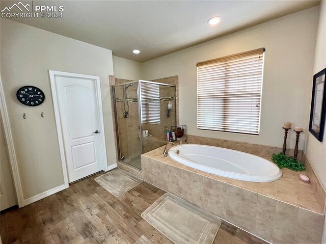 bathroom with separate shower and tub and wood-type flooring