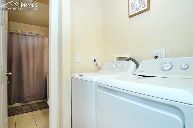 laundry area with light tile patterned floors and washer and clothes dryer