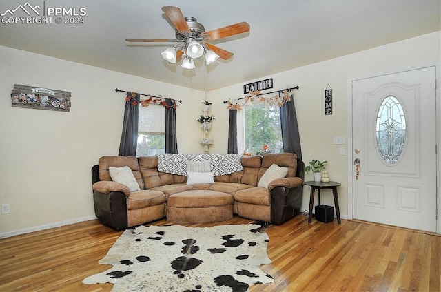 living room with ceiling fan, light wood-type flooring, and a healthy amount of sunlight