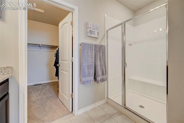 bathroom with vanity, tile patterned floors, and a shower with door