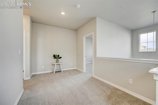 unfurnished room featuring light colored carpet